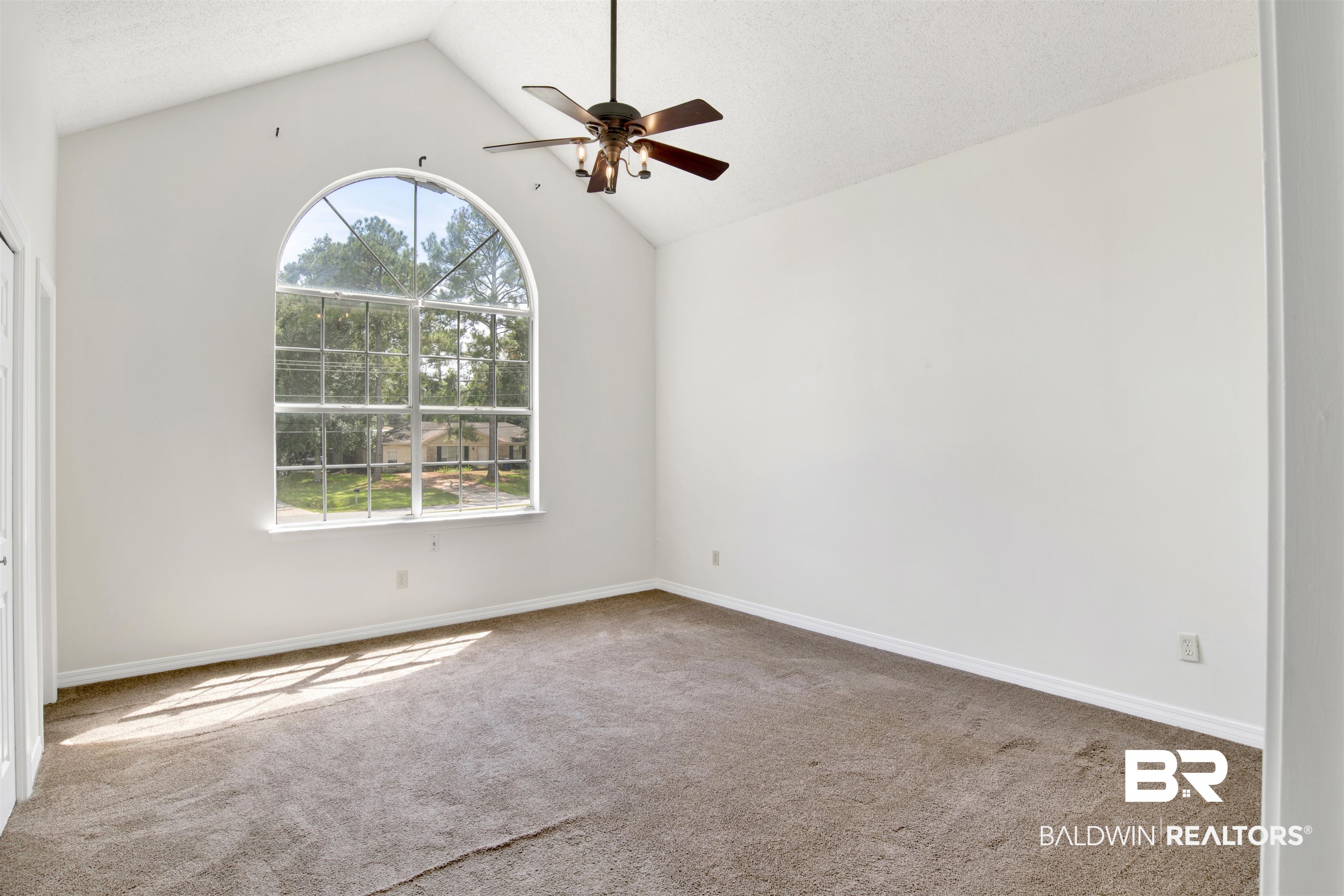 5480 Country Club Boulevard Theodore, AL 36582 - Photo 25 of 36 Empty room featuring a wealth of natural light, ceiling fan, carpet floors, and vaulted ceiling