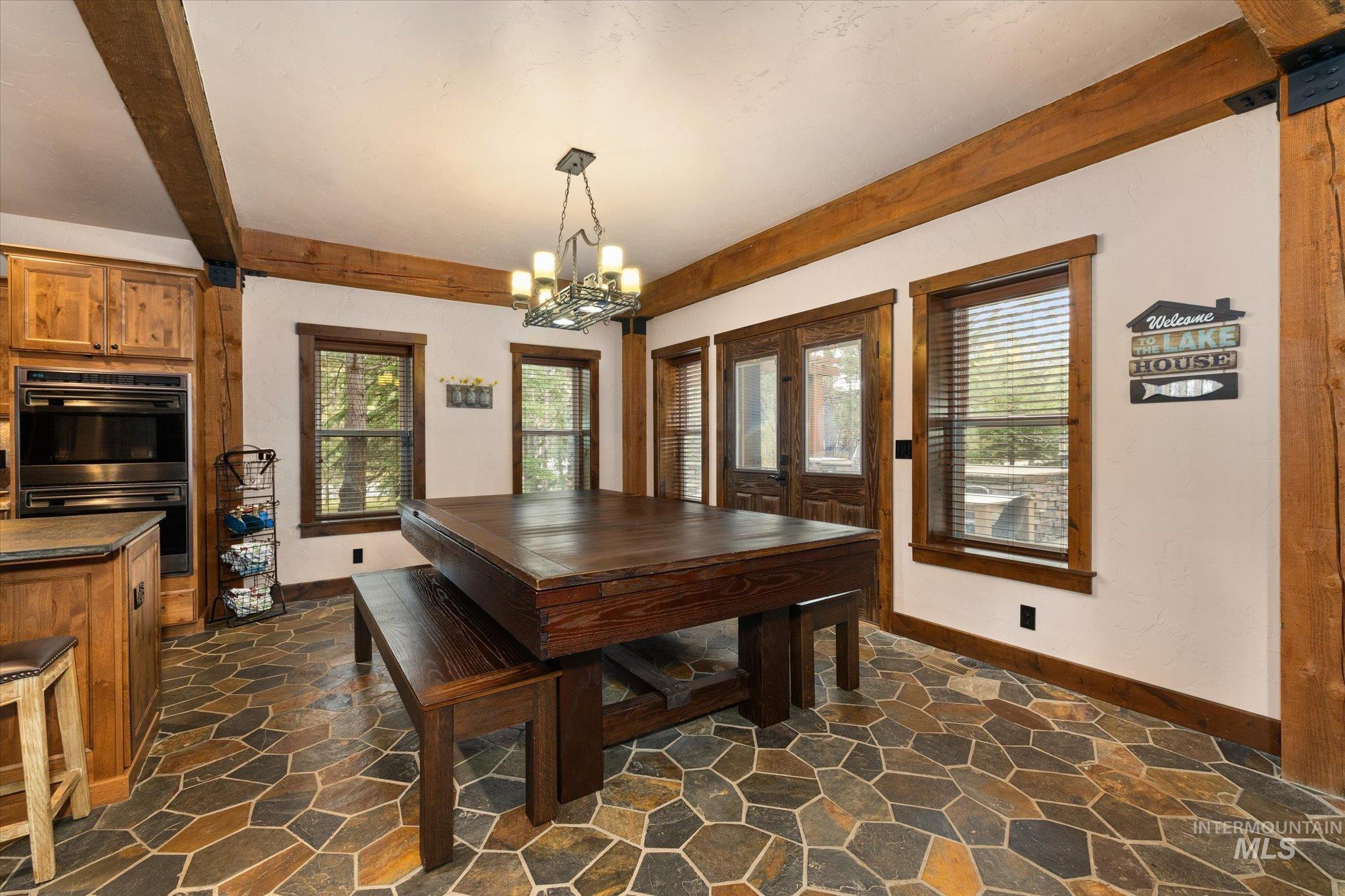14 Pointe At Goldfork Court Donnelly, ID 83615 - Photo 18 of 49 Spacious kitchen and dining area featuring natural wood beams, stone tile flooring, and double ovens