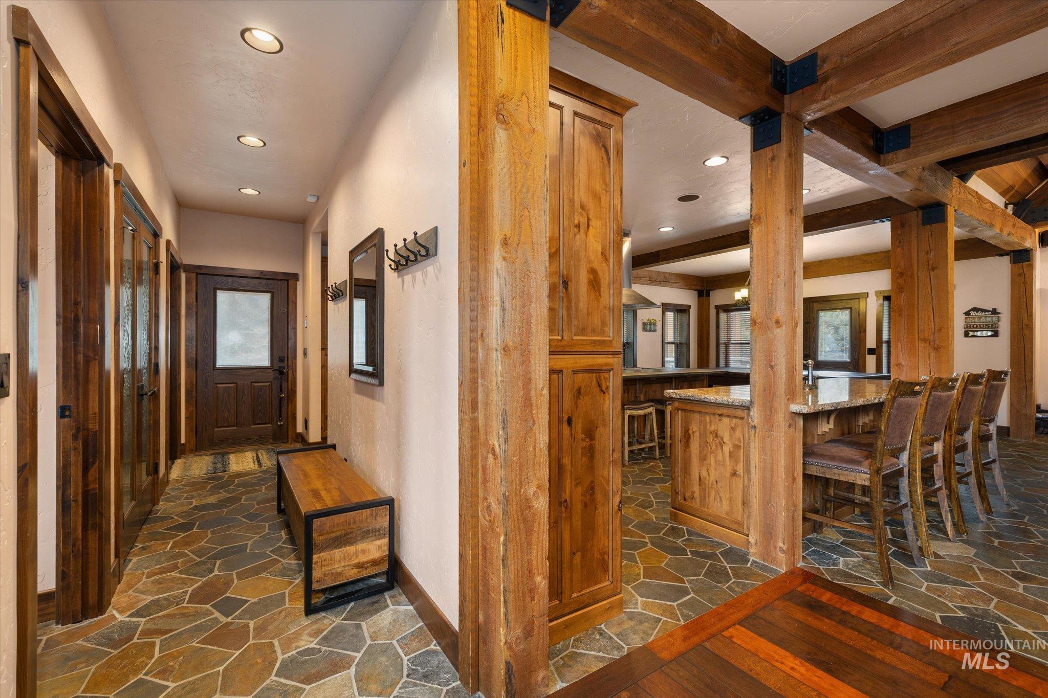14 Pointe At Goldfork Court Donnelly, ID 83615 - Photo 19 of 49 Foyer and kitchen area featuring natural wood beams, stone-finish flooring, recessed lighting, and rich wood cabinetry