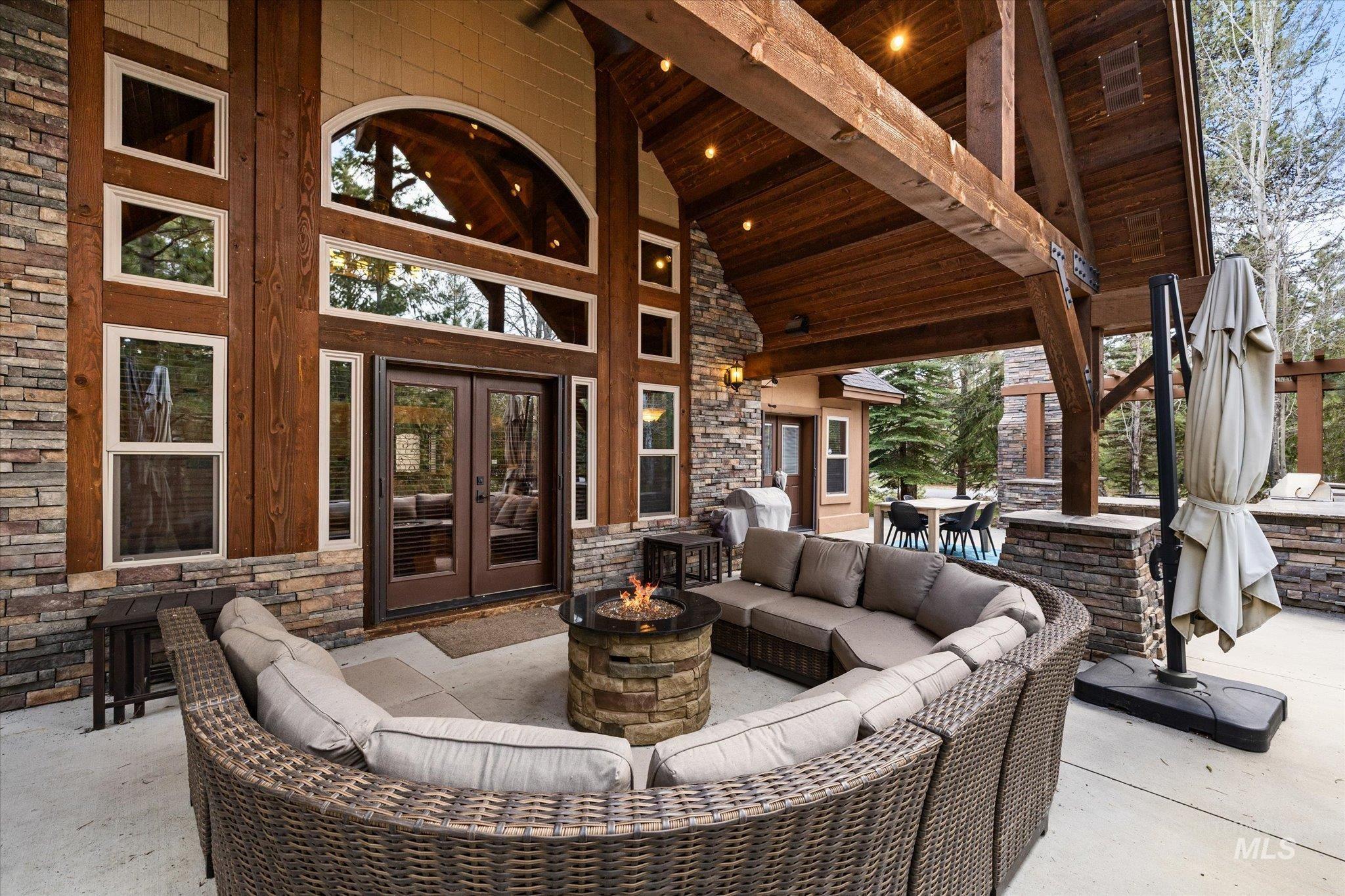 14 Pointe At Goldfork Court Donnelly, ID 83615 - Photo 37 of 49 Expansive outdoor living area featuring a stone-clad exterior, exposed timber beams, and a built-in fire pit