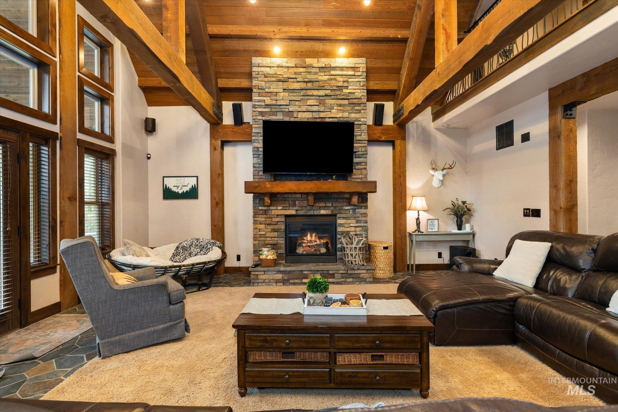 14 Pointe At Goldfork Court Donnelly, ID 83615 - Photo 8 of 49 Spacious living area featuring a vaulted wood-beam ceiling, stone-clad fireplace, and large windows with integrated blinds