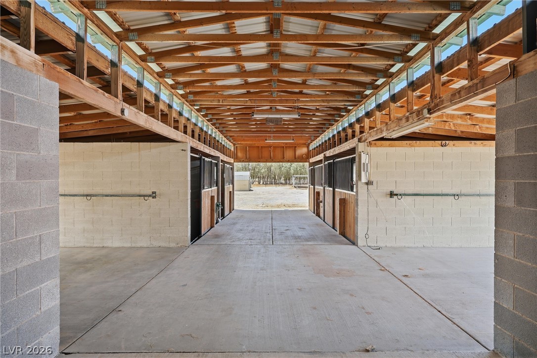 1531 West Harris Farm Road Pahrump, NV 89060 - Photo 11 of 37 Well-appointed stables with concrete flooring and exposed beam ceilings offer prime equestrian facilities.