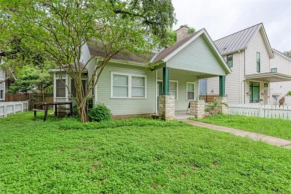 a front view of a house with a yard and trees
