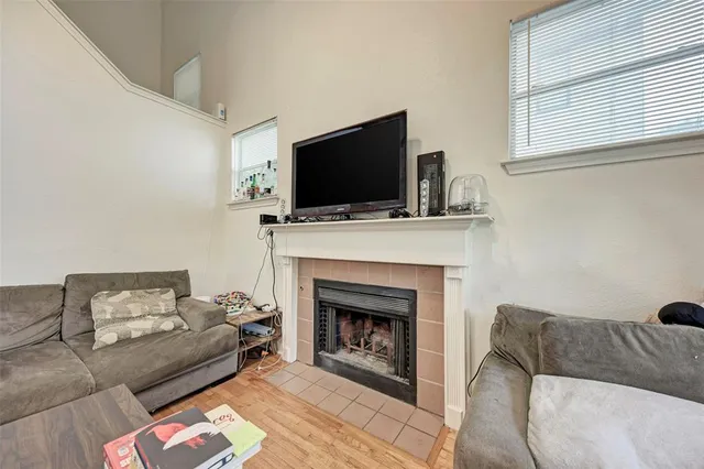 a living room with furniture a flat screen tv and a fireplace