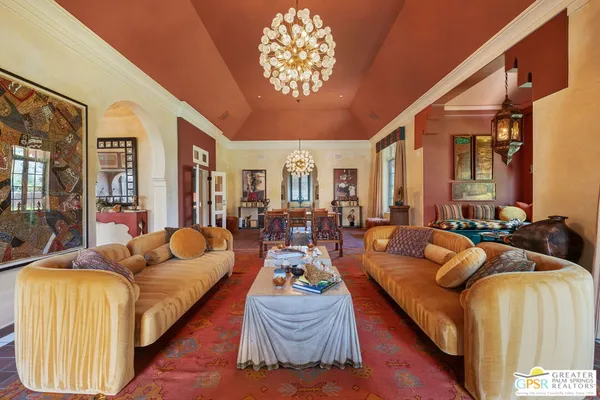 a dining room with furniture a chandelier and wooden floor