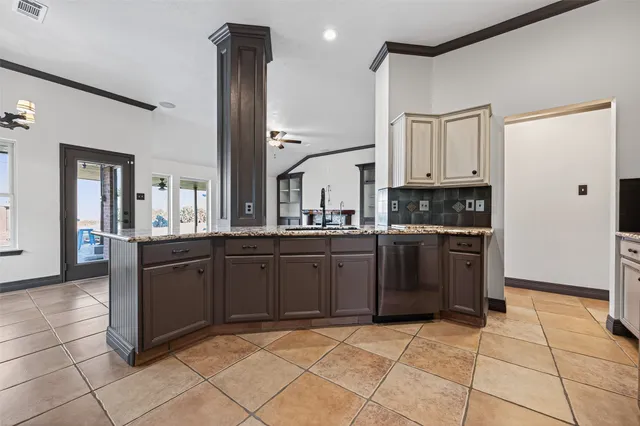 a kitchen with granite countertop a refrigerator and a stove top oven