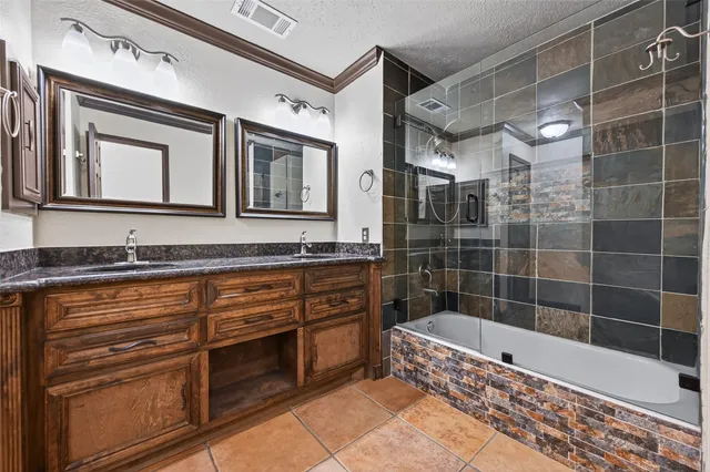 a bathroom with a granite countertop sink a mirror and cabinets
