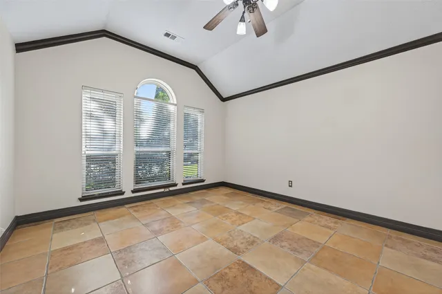 a view of an empty room with a chandelier fan