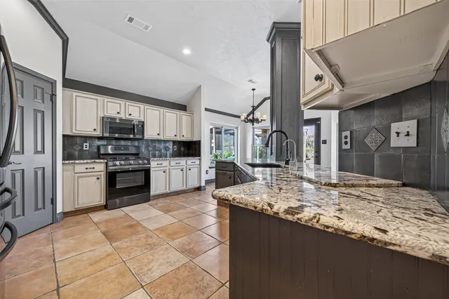 a kitchen with stainless steel appliances granite countertop a stove a sink and a refrigerator