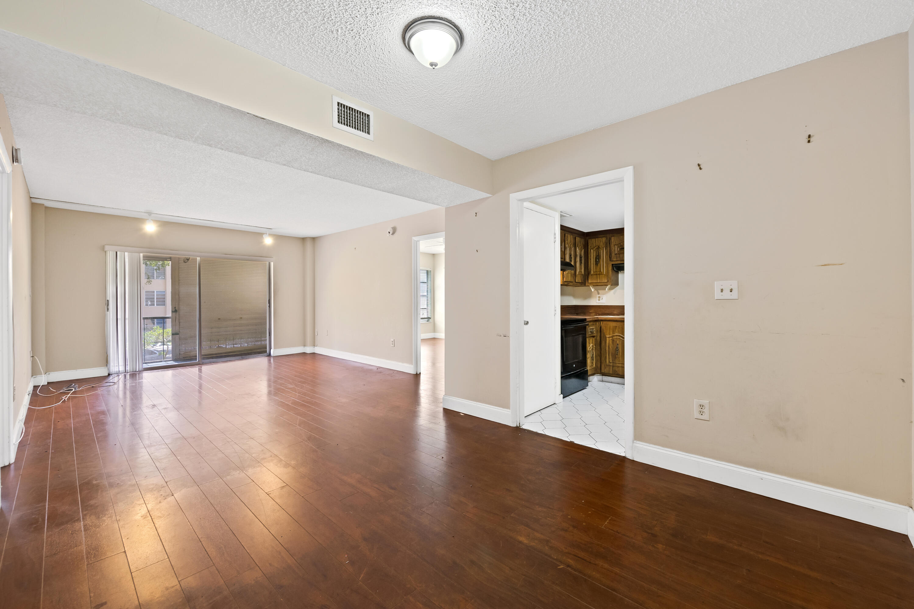 4156 Inverrary Drive, Unit 210 Lauderhill, FL 33319 - Photo 21 of 27 a view of an empty room with wooden floor and a window