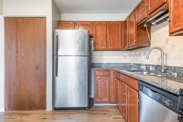 a view of an empty room with wooden floor and closet