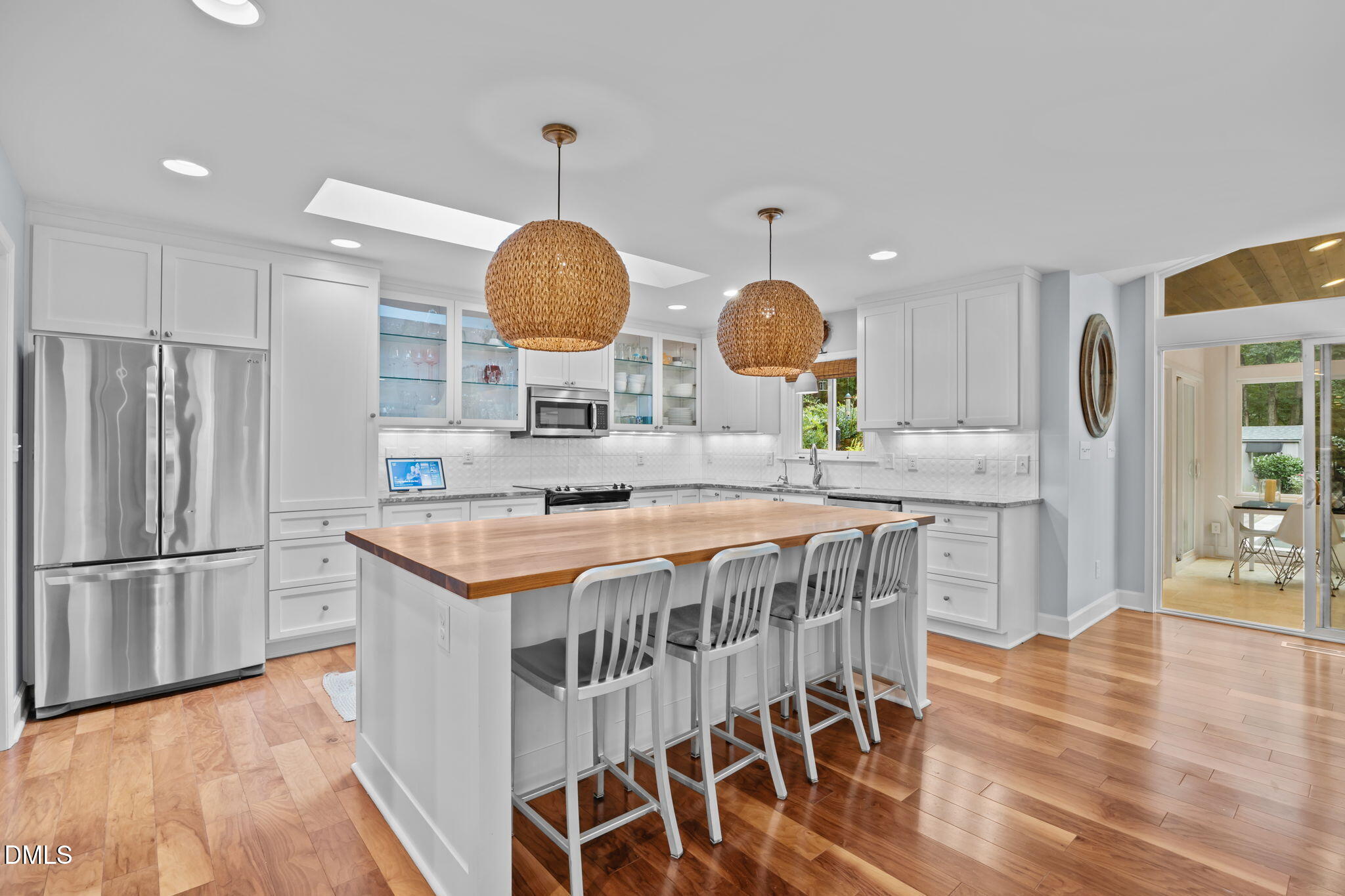 1812 Rolling Road Chapel Hill, NC 27514 - Photo 19 of 72 a kitchen with stainless steel appliances a stove a refrigerator a kitchen island and chairs in it
