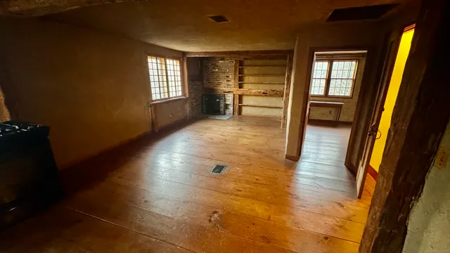 wooden floor in an empty room with a window