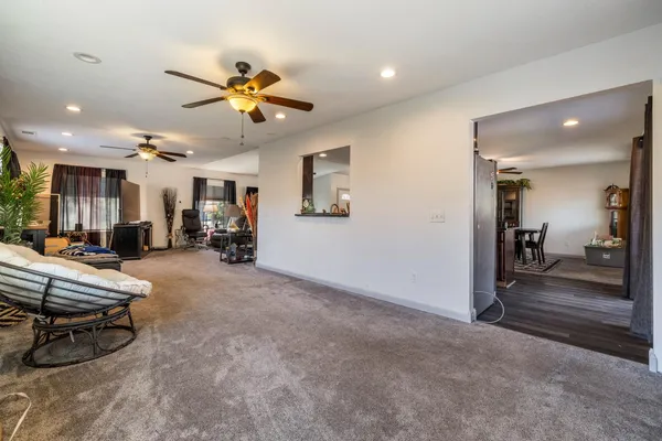 a living room with furniture a ceiling fan and a rug