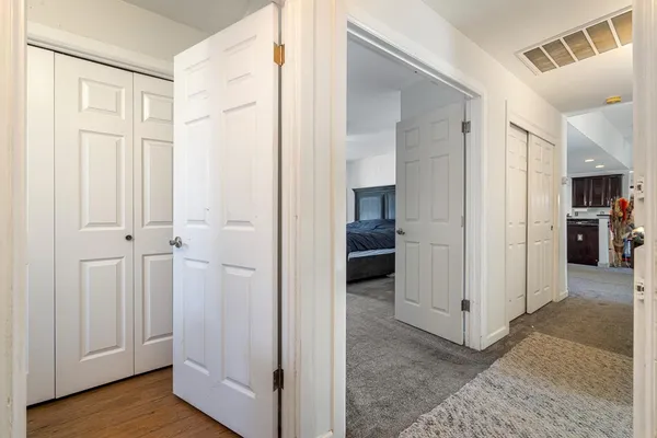 a view of a hallway with wooden floor and closet area