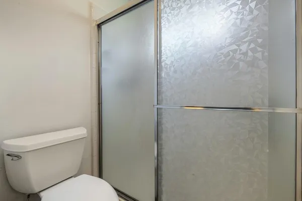 a white toilet sitting next to a shower