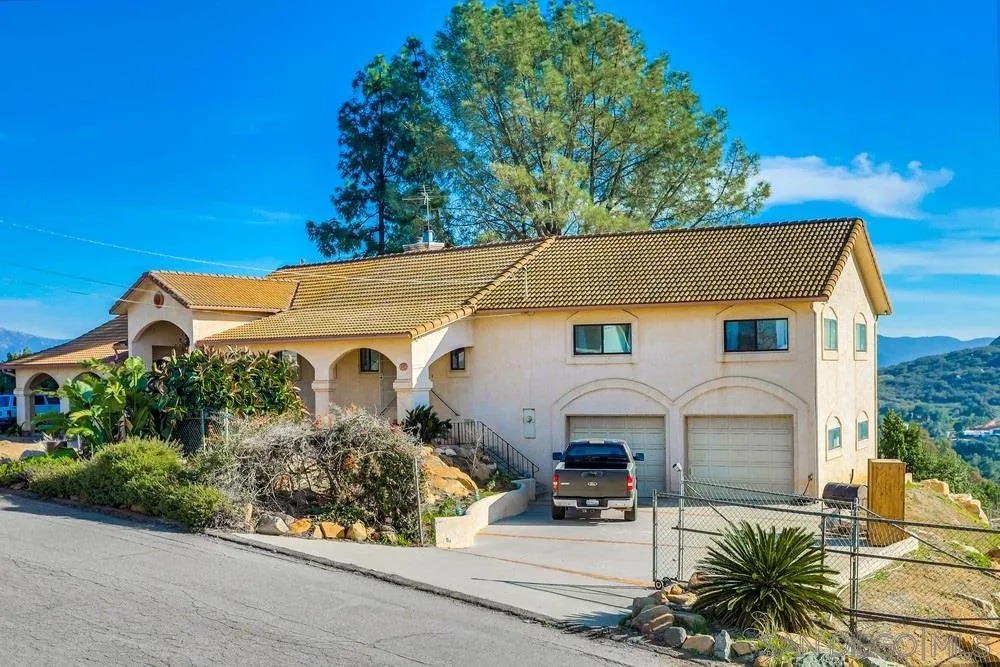 a view of a white house with large windows and plants