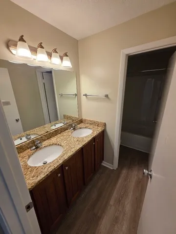 a bathroom with a double vanity sink and mirror