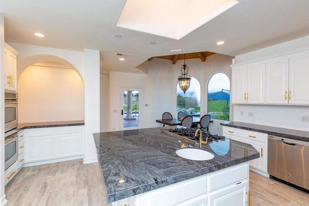 9650 Covey Lane Escondido, CA 92026 - Photo 20 of 39 a bathroom with a granite countertop sink a mirror and a shower