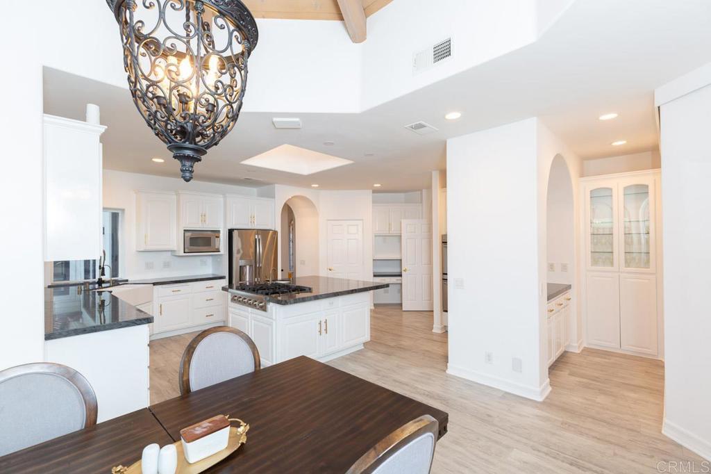9650 Covey Lane Escondido, CA 92026 - Photo 22 of 39 a kitchen with stainless steel appliances a dining table chairs and granite counter tops