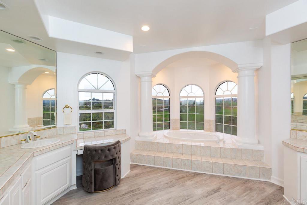 9650 Covey Lane Escondido, CA 92026 - Photo 28 of 39 a bathroom with a granite countertop tub a sink and a large window
