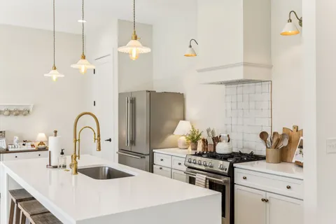 a kitchen with kitchen island a counter top space a sink stainless steel appliances and cabinets