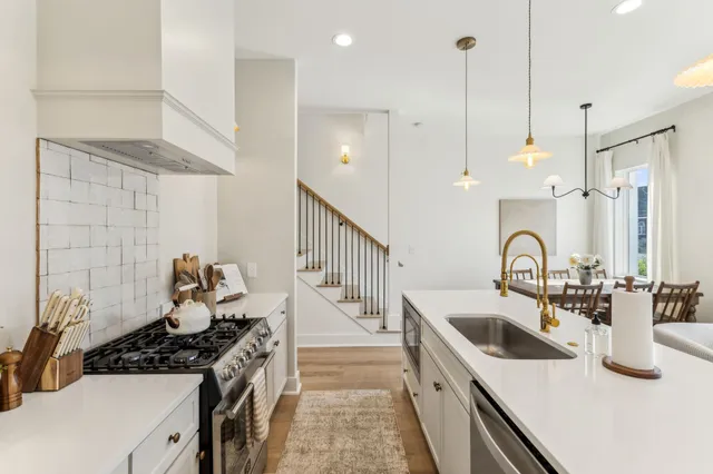 a kitchen with kitchen island a sink and a stove with wooden floor
