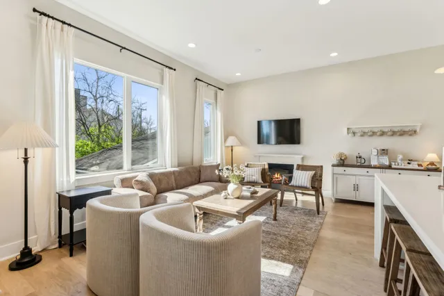 a kitchen with stainless steel appliances a stove a sink a oven a dining table and chairs