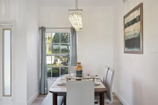 a dining room with furniture a chandelier and wooden floor
