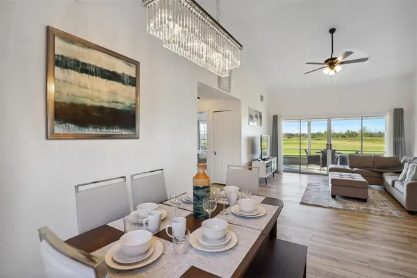 a dining room with furniture a large window and wooden floor