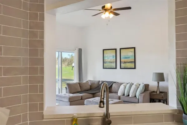 a living room with furniture and a ceiling fan