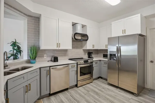 a kitchen with white cabinets stainless steel appliances and a counter space