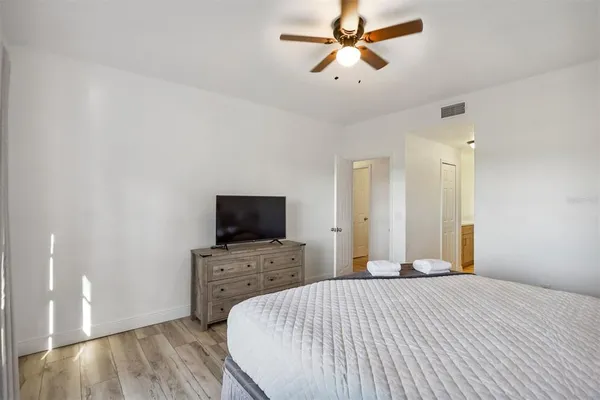 a bedroom with a bed and a flat tv screen on a dresser