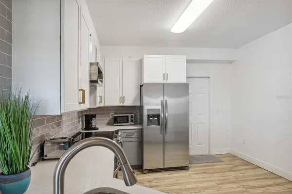 a kitchen with stainless steel appliances a refrigerator sink and cabinets