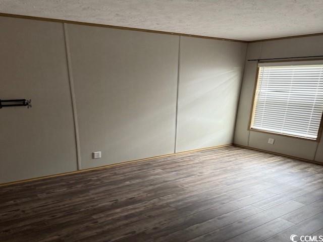65 Clemmons Drive Tabor City, NC 28463 - Photo 22 of 29 Unfurnished room with a textured ceiling, wood finished floors, and ornamental molding