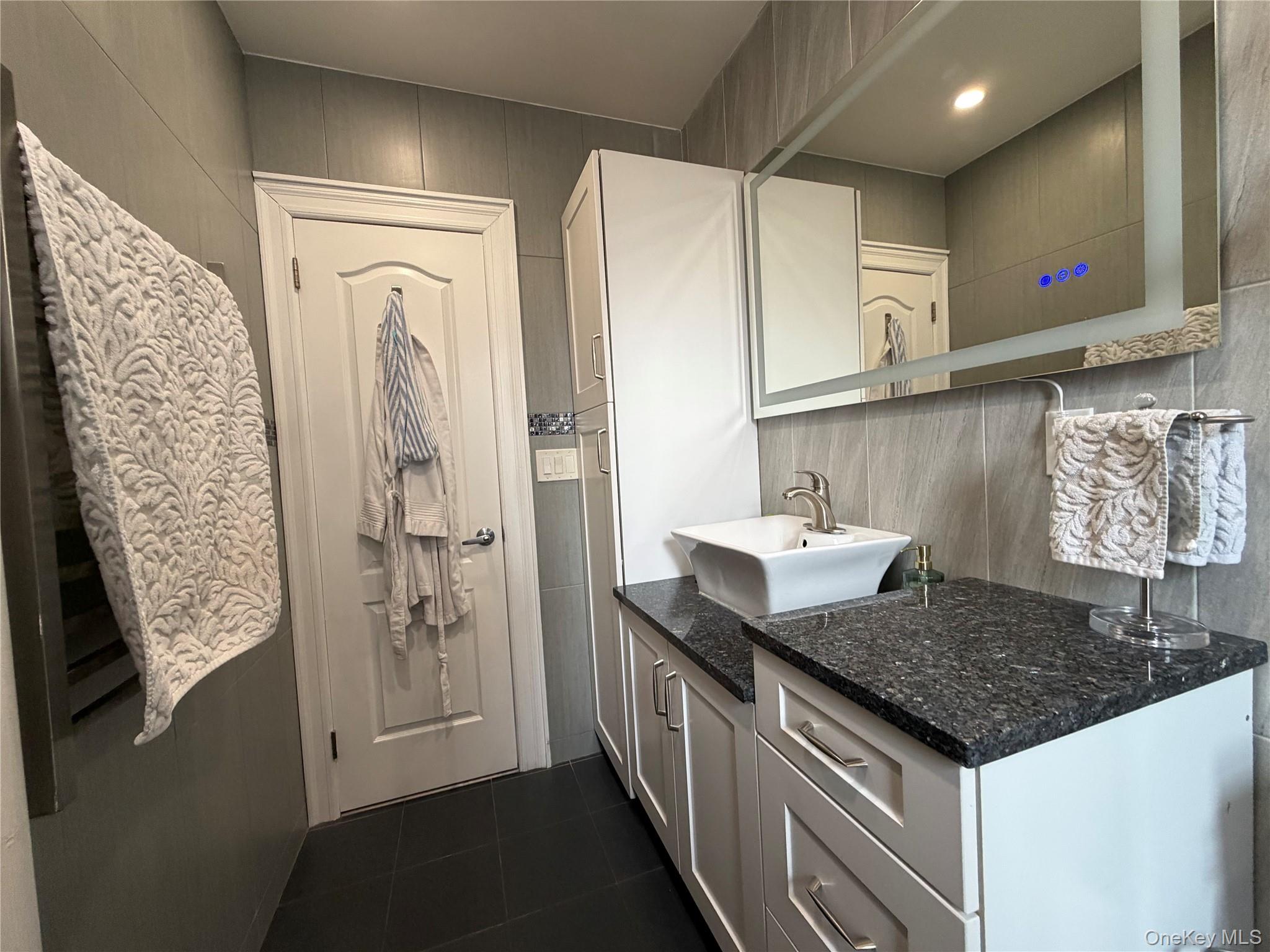 8384 116th Street, Unit 5G Queens, NY 11418 - Photo 11 of 17 a kitchen with stainless steel appliances granite countertop a sink stove and refrigerator