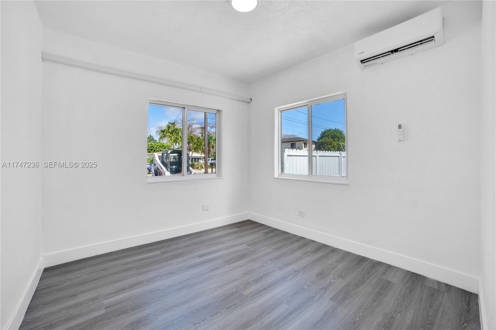 10272 Southwest 178th Street, Unit 1 Miami, FL 33157 - Photo 6 of 8 a view of an empty room with wooden floor and window
