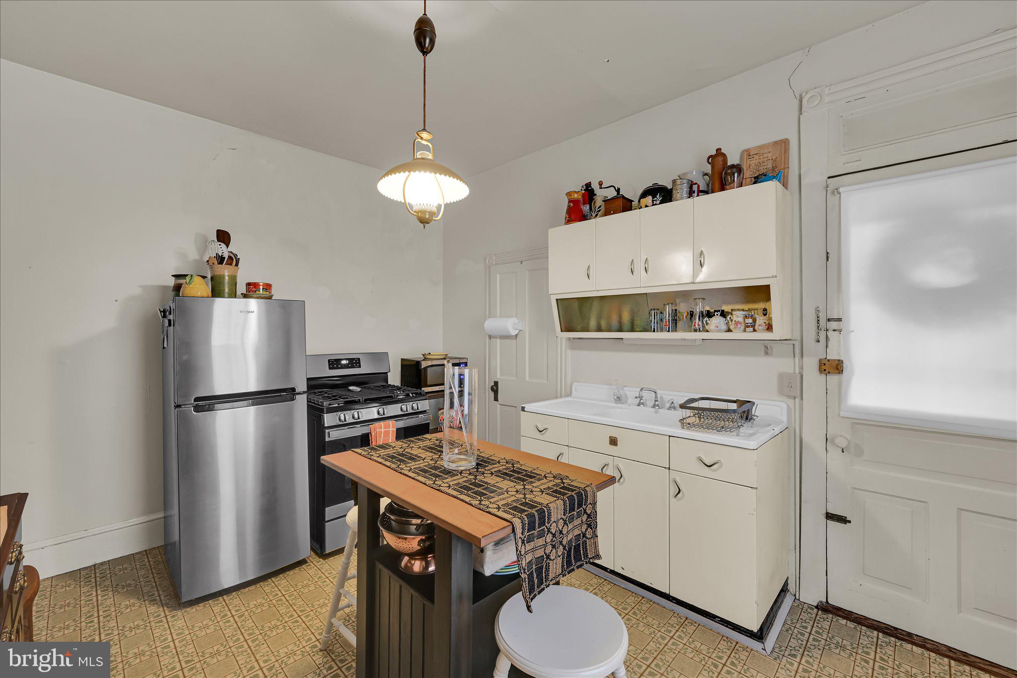529 Windsor Street Reading, PA 19601 - Photo 12 of 36 a kitchen with a stove a refrigerator and a sink