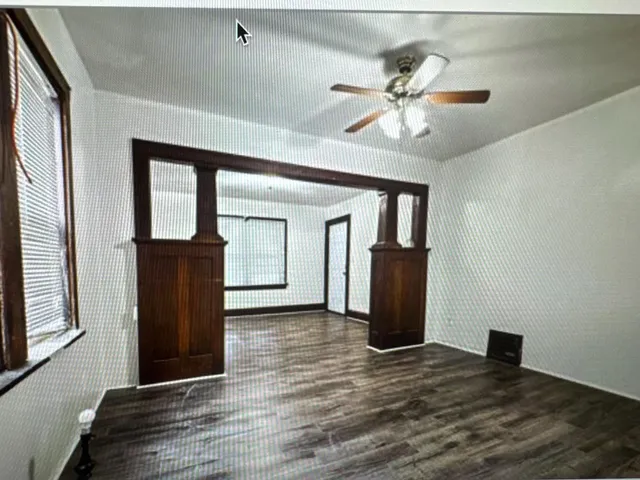 a view of a hallway with wooden floor and a ceiling fan