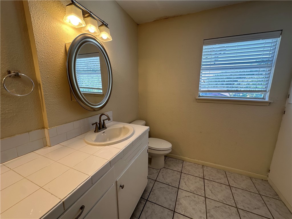 104 Frio Drive Portland, TX 78374 - Photo 34 of 37 a bathroom with a sink a toilet and a mirror