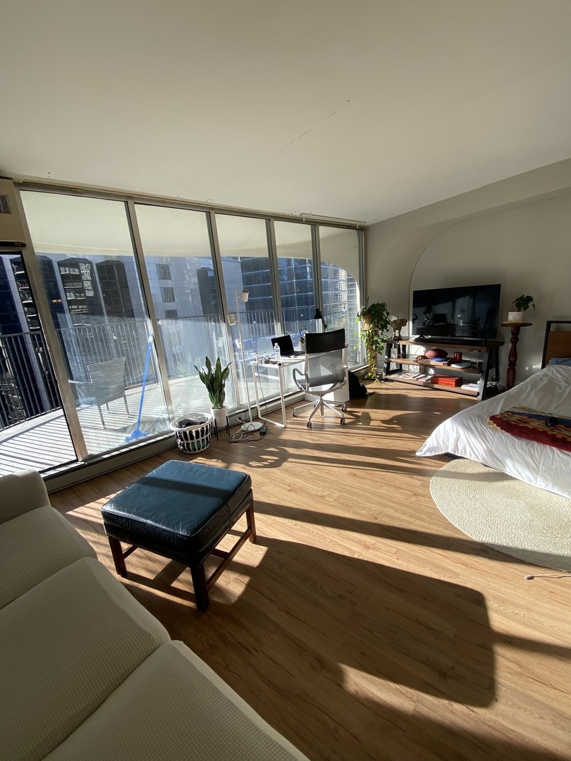 300 North State Street, Unit 2103 Chicago, IL 60654 - Photo 2 of 26 a living room with furniture and a flat screen tv