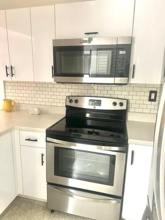 a stove top oven sitting inside of a kitchen
