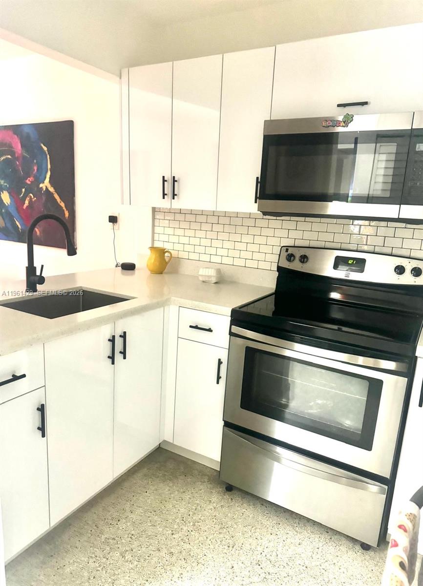 755 Southwest 6th Street, Unit 6 Miami, FL 33130 - Photo 9 of 20 a kitchen with stainless steel appliances a stove and a microwave