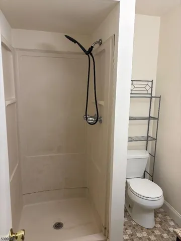 a bathroom with a toilet and a shower
