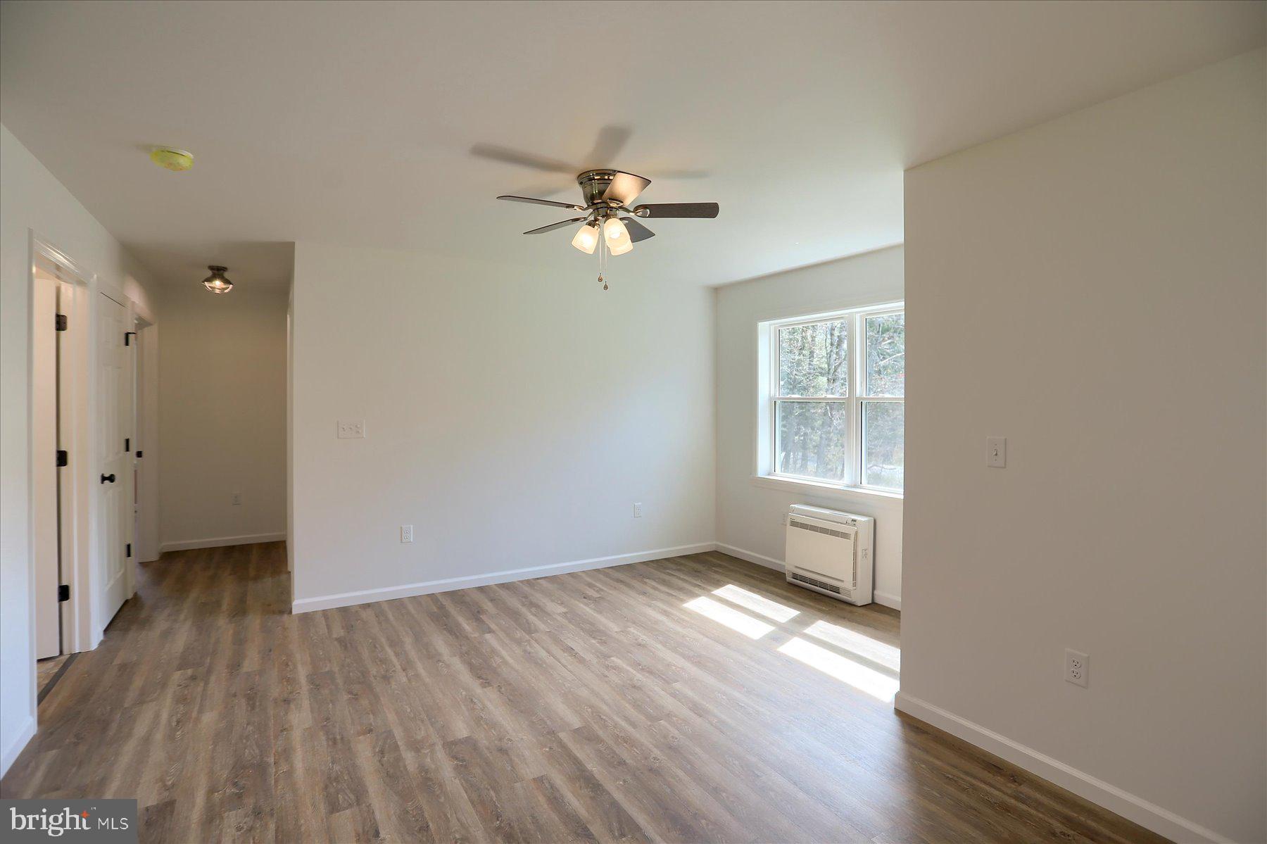 3497 New Lancaster Valley Road Milroy, PA 17063 - Photo 11 of 30 an empty room with wooden floor chandelier fan and windows