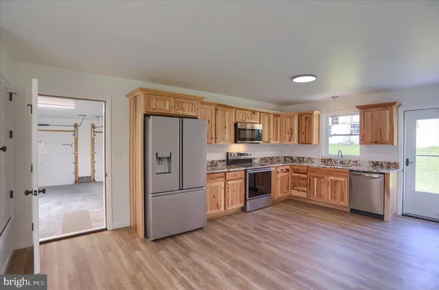a kitchen with granite countertop wooden floors and stainless steel appliances