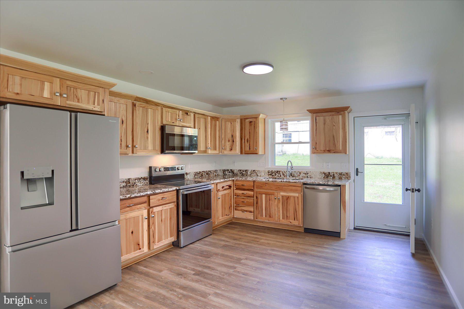 3497 New Lancaster Valley Road Milroy, PA 17063 - Photo 9 of 30 a kitchen with granite countertop stainless steel appliances a refrigerator stove top oven and sink