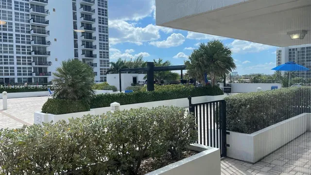 a view of a house with a small yard and large trees