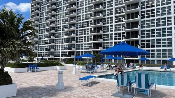 a view of a patio with a table and chairs under an umbrella