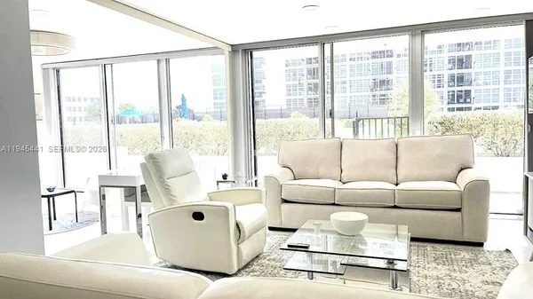 a living room with furniture and large windows